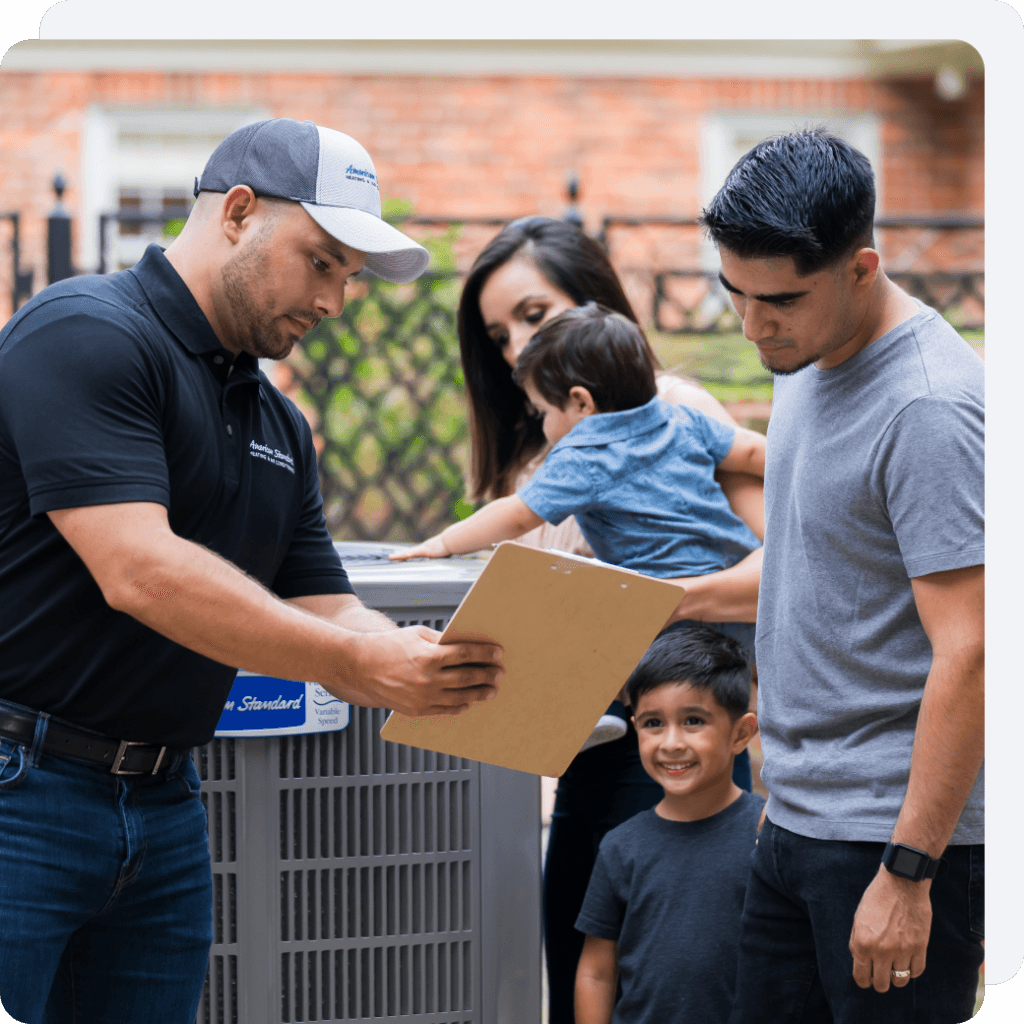 A family standing around an HVAC unit with a technician.