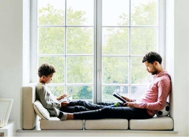 A father and son enjoy reading together.
