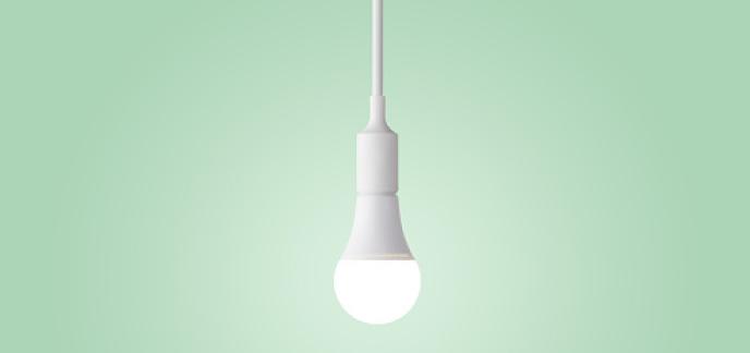 An energy efficient light bulb against a green background.