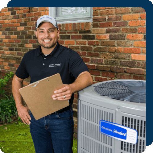 An HVAC dealer stands beside an outdoor unit.