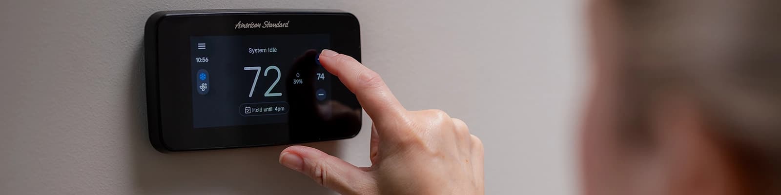 Female Homeowner Setting the Gold Smart Thermostat