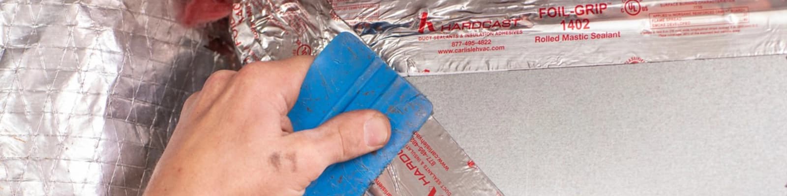 Closeup of HVAC Technician Sealing Sheet Metal Ductwork with Mastic Tape